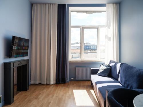 a living room with a couch and a window at MIRO Rooms Center - quiet chic, self check-in in Rīga