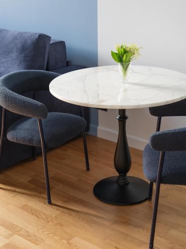 a white table and chairs with a vase on it at MIRO Rooms Center - quiet chic, self check-in in Rīga