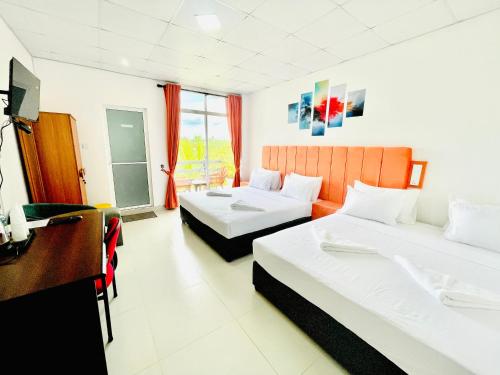 a hotel room with two beds and a television at Ismattha Hotel in Anuradhapura