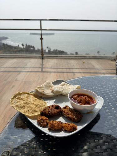 a plate of food with meatballs and chips and a bowl of dips at NIRAKI VILLA by Seascapes in Harnai
