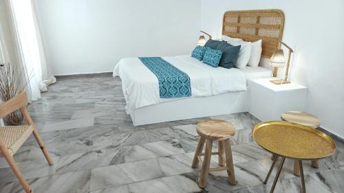 a bedroom with a bed and two stools at Narges Hotel in Aliki