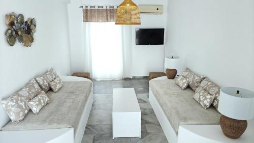 a living room with two couches and a table at Narges Hotel in Aliki