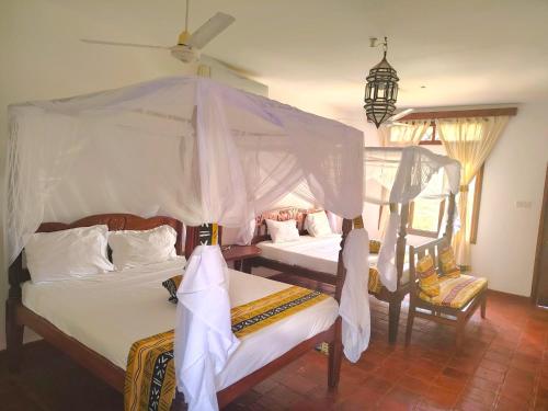 Postel nebo postele na pokoji v ubytování Gecko Hotel Diani