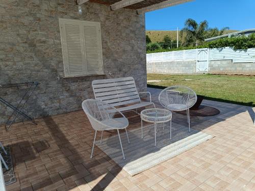 a patio with two chairs and a white chair and a table at Janus Casa nel Verde - Relax Pool & Spa in Giano Vetusto