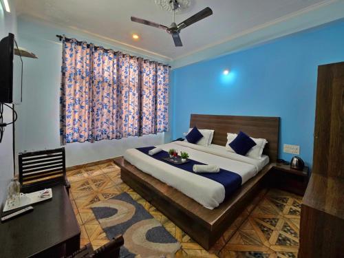 a bedroom with a large bed with blue walls at Hotel City Gold - Hotel in Dharamshala in Dharmsala
