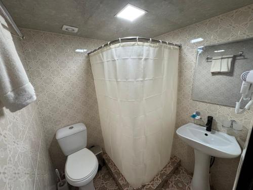 a bathroom with a white toilet and a sink at Garden Palace Khiva in Khiva