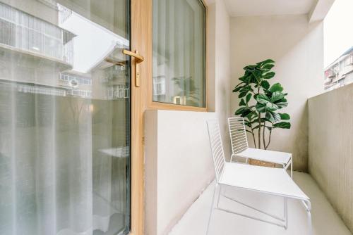 a white chair sitting on a balcony next to a window at Guan Erjie Boutique Hotel (Huimin Street of Xi'an Bell Tower ) in Xi'an