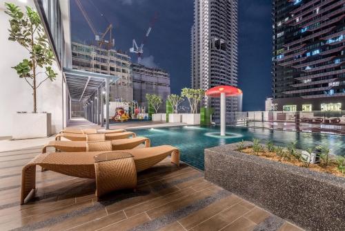 a swimming pool in a city with tall buildings at Cozy Stay in KLCC吉隆玻 in Kuala Lumpur
