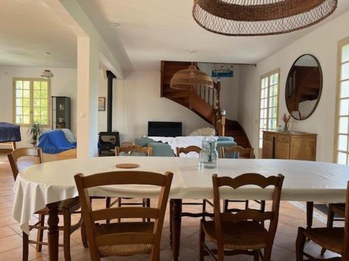 Una sala de estar con una mesa y sillas blancas. en Maison Familiale vue mer et plage à pieds, en Ploubazlanec