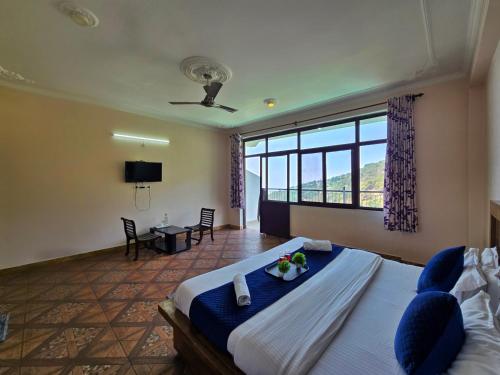 a bedroom with a bed and a large window at Hotel City Gold - Hotel in Dharamshala in Dharmsala