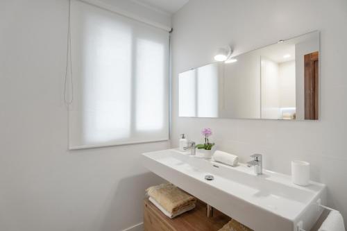 ein weißes Badezimmer mit Waschbecken und Spiegel in der Unterkunft La Casa de Los Gigantes in Acantilado de los Gigantes