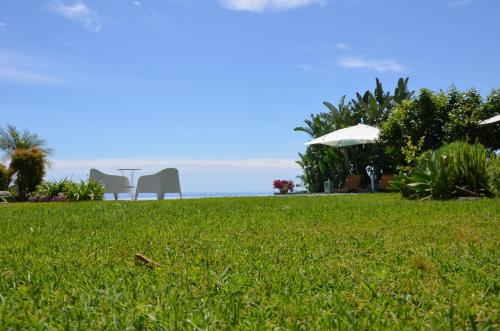 a lawn with a table and chairs and the ocean at La casa del panorama in Valverde
