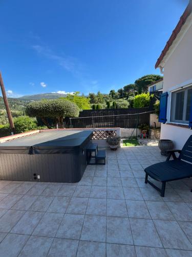 a patio with a picnic table and a bench at Villa au calme à Grasse avec piscine et spa privée in Grasse