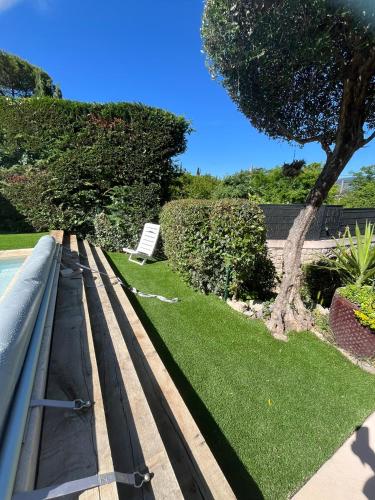 a park bench with a tree and a lawn at Villa au calme à Grasse avec piscine et spa privée in Grasse