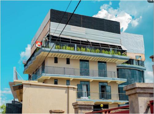 a building with a balcony with plants on it at Free Gate Accommodation in Ruhengeri