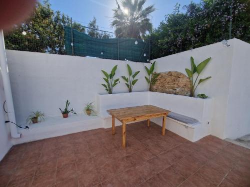 a wooden bench sitting on a white wall with plants at Mammì in Balestrate