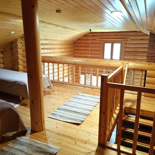 a log cabin with a staircase and a bedroom at Kolilla oy, Purnutar B in Kolinkylä