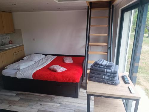 une chambre avec un lit avec une couverture rouge dans l'établissement Studio familial avec terrasse et parking à proximité de la gare TGV Aix-en Provence, à Cabriès