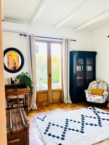a living room with a table and a chair and a rug at La Villa Bohème in Oppède
