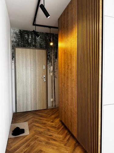 a room with a hallway with a wooden door at Japandi Apartment Pogórze in Pogórze