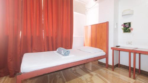 a small room with a bed and a curtain at Stay Malate Hostel by RedDoorz in Manila