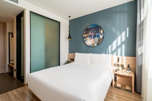 Un dormitorio con una cama blanca grande y una ventana en Atour Hotel Shanghai Lujiazui Minsheng Road Station, en Shanghái