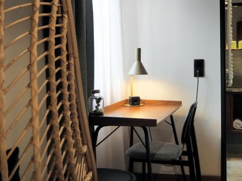 a desk with a lamp and a chair next to a window at Cocoon Salzburg in Salzburg