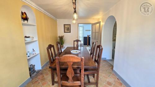 a dining room with a wooden table and chairs at Maison authentique du Vexin in Théméricourt