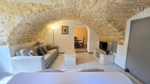 a bedroom with a couch and a tv in a room at Maison authentique du Vexin in Théméricourt