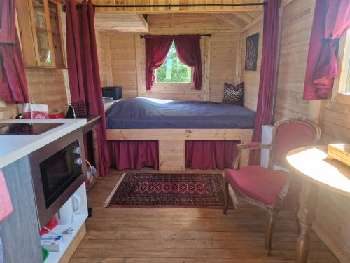 - une chambre avec un lit dans une petite maison dans l'établissement Roulotte La Maison Des Trois Grands, à Sannat