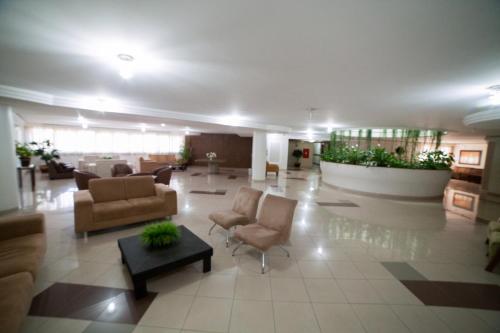 a lobby with couches and chairs in a building at Copas Executive Hotel in Cascavel
