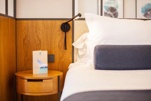 a hotel room with a bed and a table with a sign at Grupotel Playa de Palma Suites & Spa in Playa de Palma