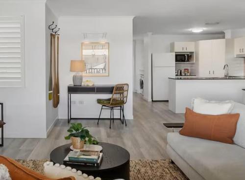 una sala de estar con un sofá y una mesa en 3-Bed Haven with Balcony and BBQ, 5-Min to Beach, en Coolum Beach