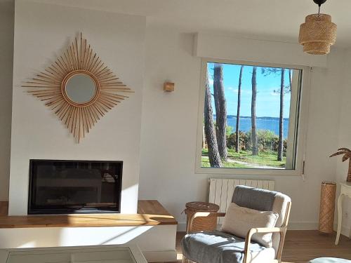 un salon avec une cheminée et un miroir dans l'établissement Maison des 3 îles, à Pénestin