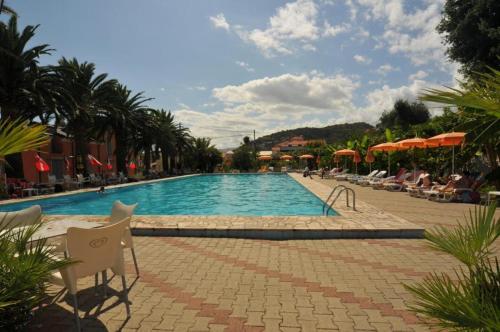 a swimming pool with chairs and umbrellas in a resort at Blu Mare Apartment in Pietra Ligure