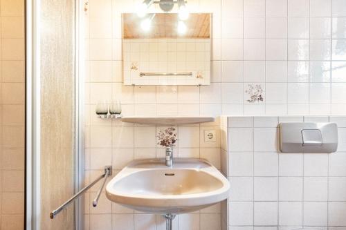 a white bathroom with a sink and a mirror at Gasthaus Hirschen Holl in Elbenschwand