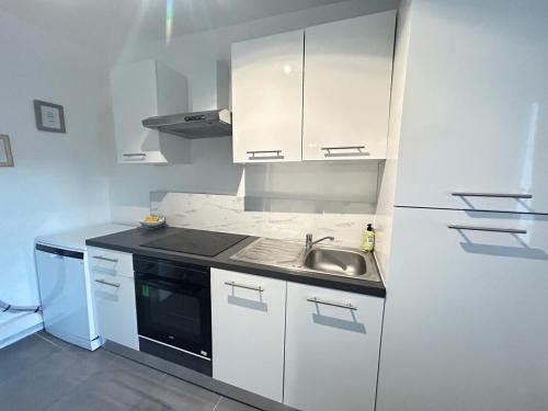 une petite cuisine avec un évier et une cuisinière dans l'établissement Le clos Champenois maison au cœur des vignes, à Avize