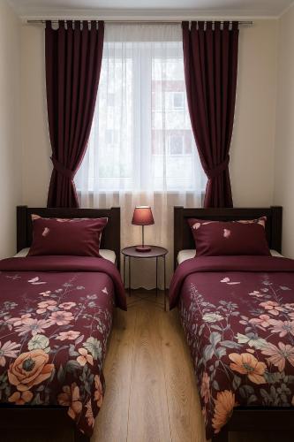 a bedroom with two beds and a window at TK Apartments Spiżowa in Wrocław