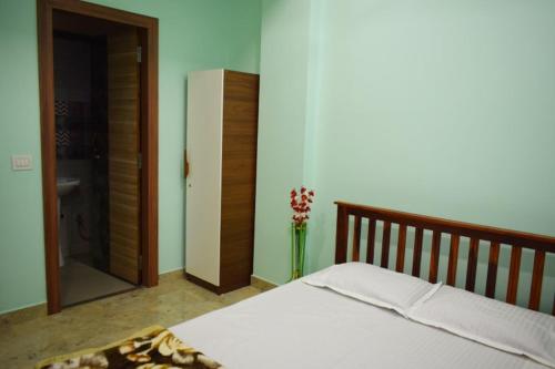 a bedroom with a white bed and a refrigerator at Jee Inn Homestay in Guwahati