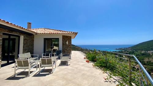d'une terrasse avec des chaises et l'océan en arrière-plan. dans l'établissement Villa Valou sea and mountain view, à Conca