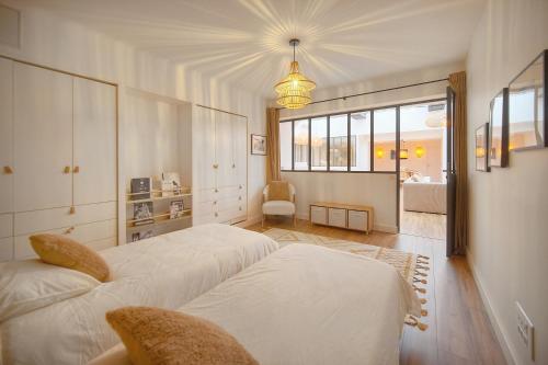 - une chambre avec 2 lits blancs et une chambre avec une fenêtre dans l'établissement Le Trendee - Loft atypique, à Cannes