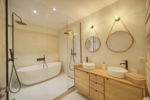 une salle de bain avec deux lavabos, une baignoire et une douche dans l'établissement Le Trendee - Loft atypique, à Cannes