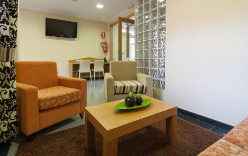 a living room with a couch and a table and chairs at Pontus Veteris in Sanxenxo