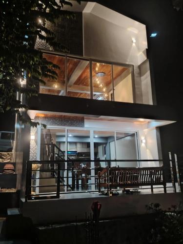 a house with a balcony with tables and chairs at E - House VILLA Kristina in Lobo