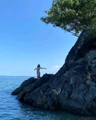 a person standing on a rock in the water at E - House VILLA Kristina in Lobo