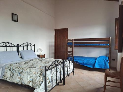 a bedroom with two bunk beds and a chair at B&B S'Omu Antiga in Nureci