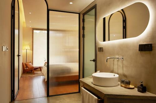 a bathroom with a sink and a mirror at Come to Xipuman B&B in Baishi