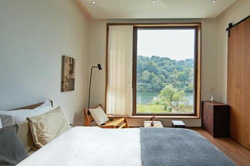 a bedroom with a bed and a large window at Come to Xipuman B&B in Baishi