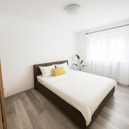 a bedroom with a large bed with white sheets at Casiana Apartments in Timişoara