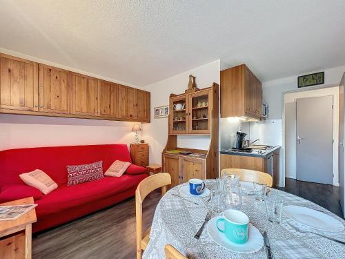 a living room with a red couch and a table at SOLEIL BLANC C27 in Montriond